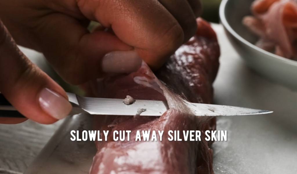 Step 3 to removing silver skin from pork tenderloin - Cut away at silverskin